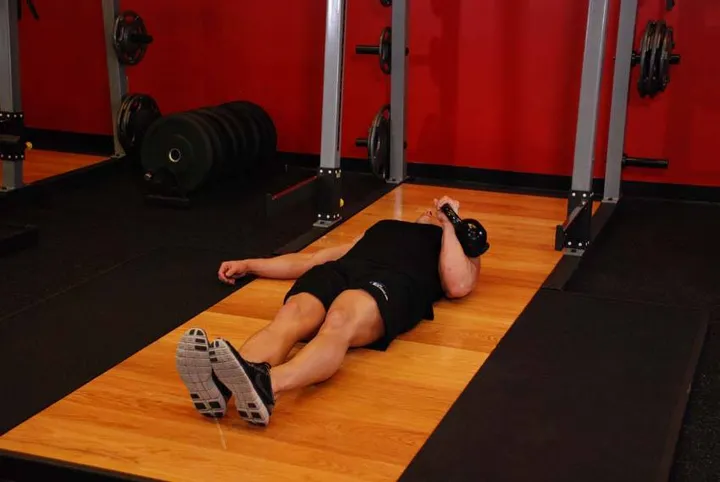 One-Arm Kettlebell Floor Press — posição inicial