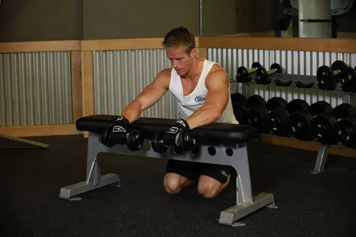 Palms-Down Dumbbell Wrist Curl Over A Bench — posição inicial