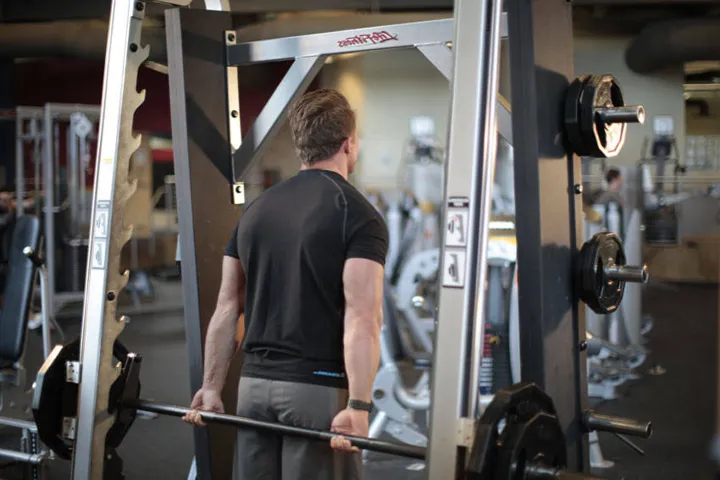 Smith Machine Behind the Back Shrug — posição inicial