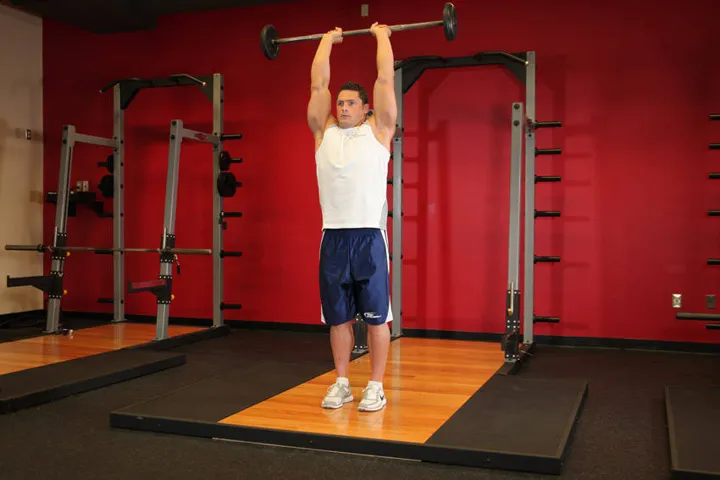Standing Overhead Barbell Triceps Extension — contração